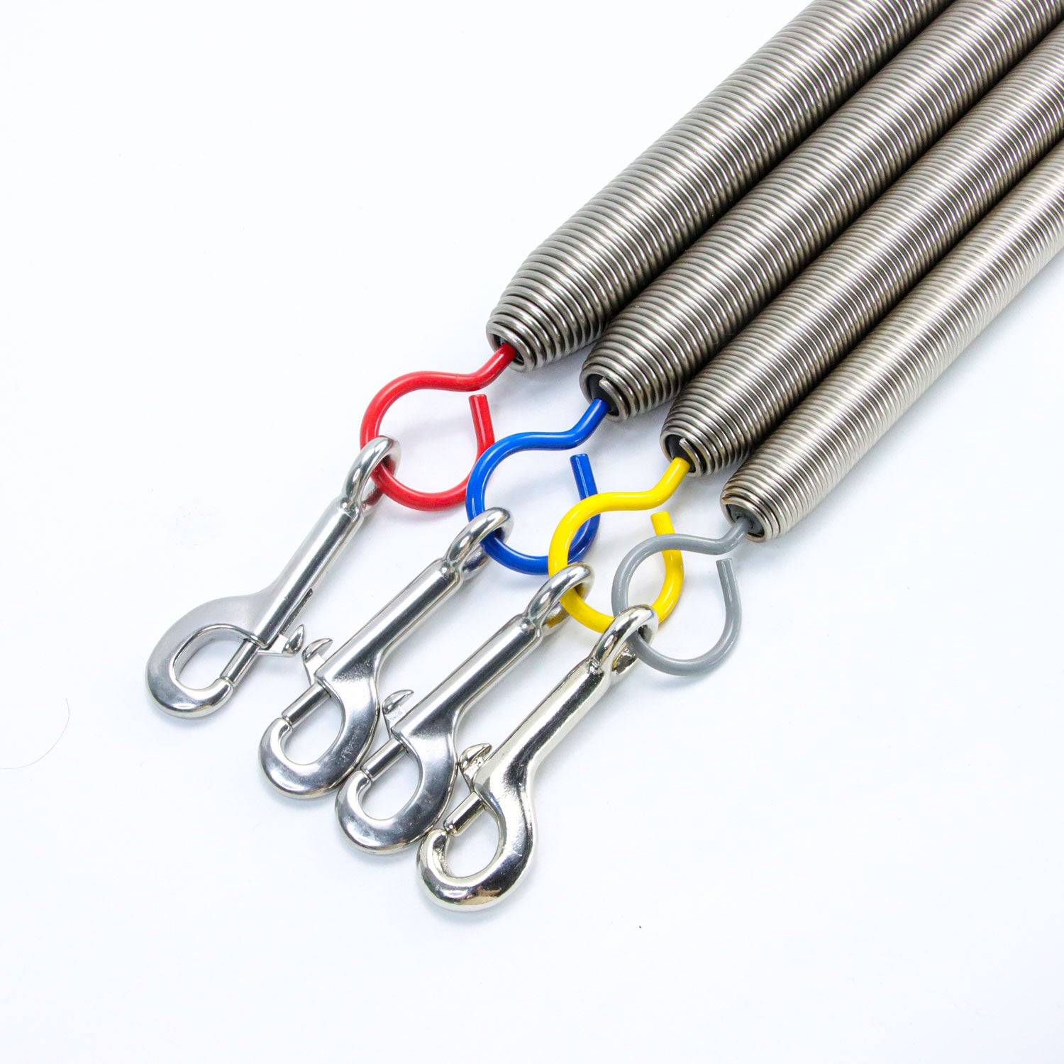 Three Balanced Body Pilates Trapeze Springs with red, blue, and yellow hooks and snap clips for Cadillac and Wall Tower resistance exercises.
